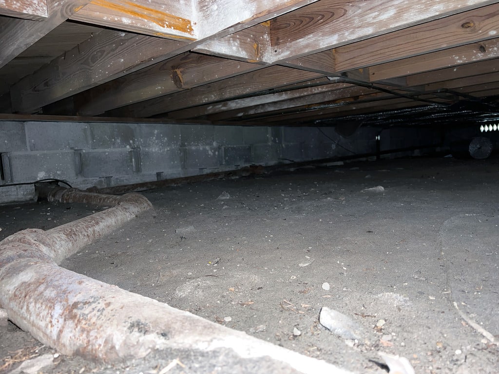 An Exposed Pipe Shows That Crawl Space Moisture Control Is Needed