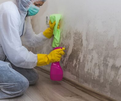 A Woman Sitting While Cleaning a Soot-Covered Wall With a Cleaning Solution and Rag Smoke Damage on Walls